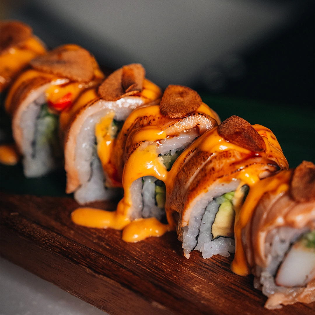 Close up of sushi preparation tools and fresh fish on cutting board