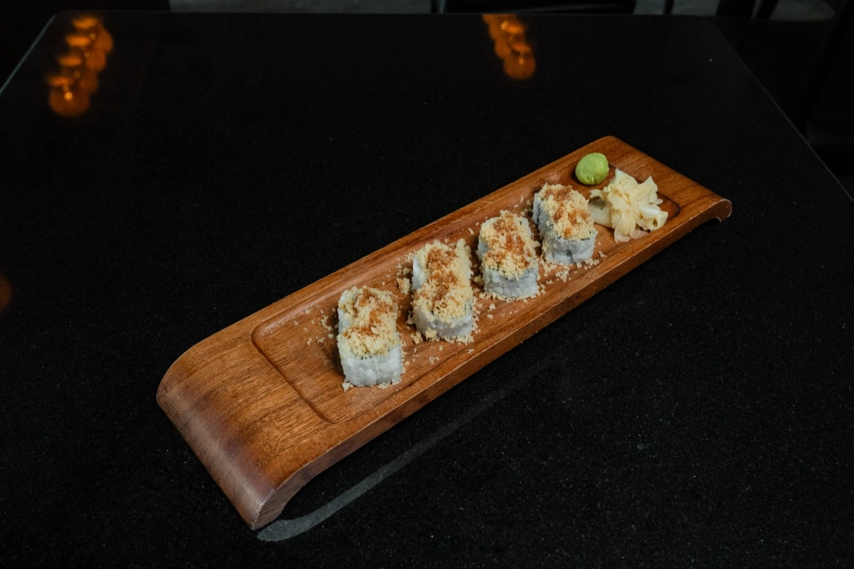 Mizu Dragon Roll with avocado and tobiko on wooden board